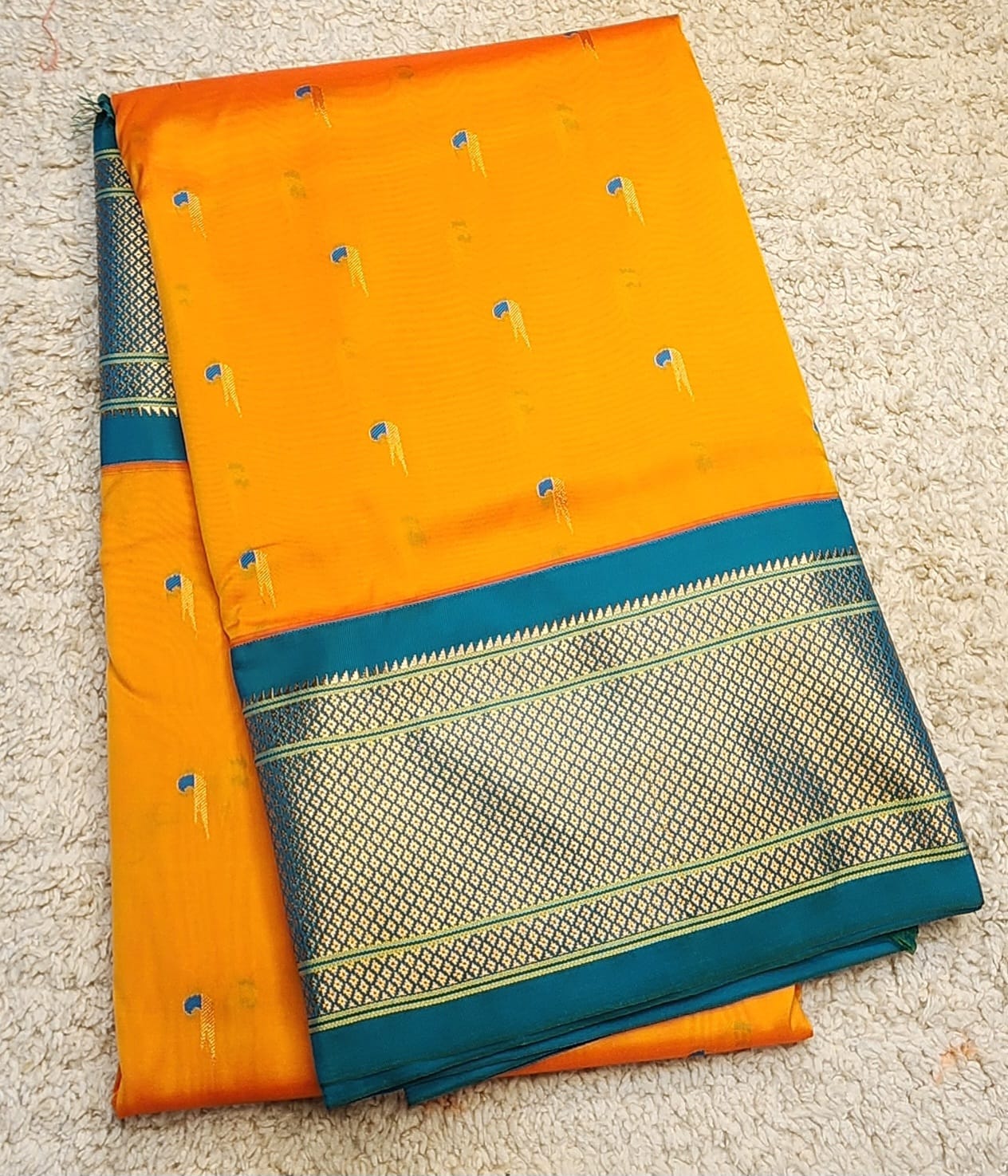Mustard yellow Paithani saree with Teal Blue Kadiyal border and muniya motif